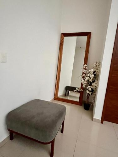a living room with a ottoman and a mirror at Casa céntrica en cuernavaca in Cuernavaca