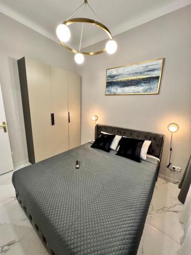 a bedroom with a large bed with black pillows at Pearl of Nice in Nice