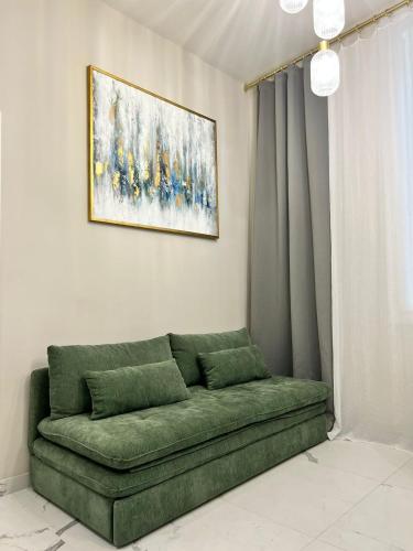 a green couch in a room with a painting on the wall at Pearl of Nice in Nice