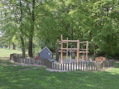 a playground in a park with a wooden fence at 6 person holiday home in Hovborg-By Traum in Hovborg