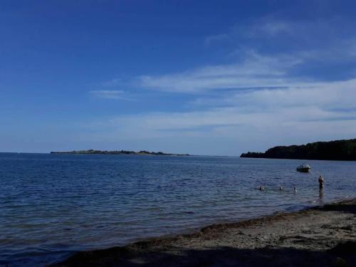 a person standing in the water at the beach at 8 person holiday home in Haderslev in Haderslev