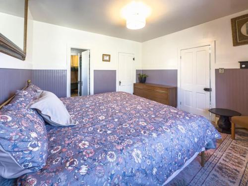 a bedroom with a large bed with a blue blanket at Historic Rock House in Helper
