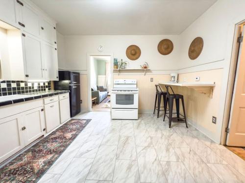 a large kitchen with white cabinets and a counter at Historic Rock House in Helper