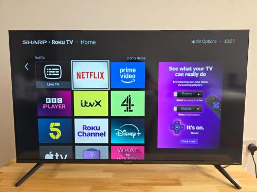 a flat screen tv sitting on top of a wooden floor at Lovely private spacious studio in Borehamwood
