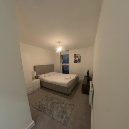 a bedroom with a bed in a white room at Luxurious Apartment Birmingham in Birmingham