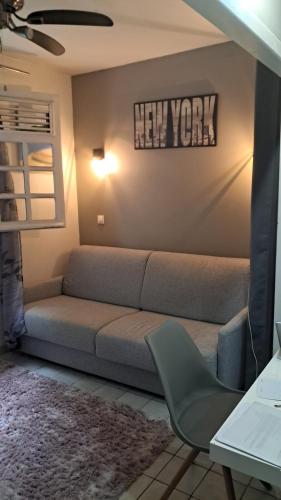 a living room with a couch and a new york sign at Grand F2, spa, jardin, parking in Schœlcher