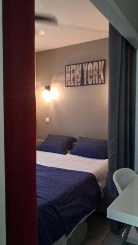 a bedroom with two beds and a sign on the wall at Grand F2, spa, jardin, parking in Schœlcher