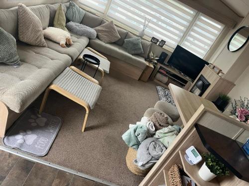 a living room with a couch and a tv at Gold Plus 3 Bed ABI Summer Breeze Modern Caravan with Sea View Pet Friendly in Aberystwyth