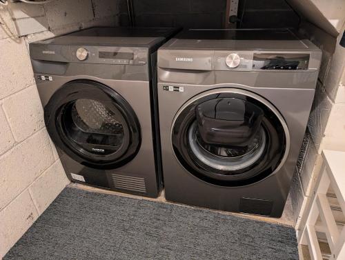 a washing machine and a washer in a room at Spacious 3 bedroom house with games room in Kirby Muxloe