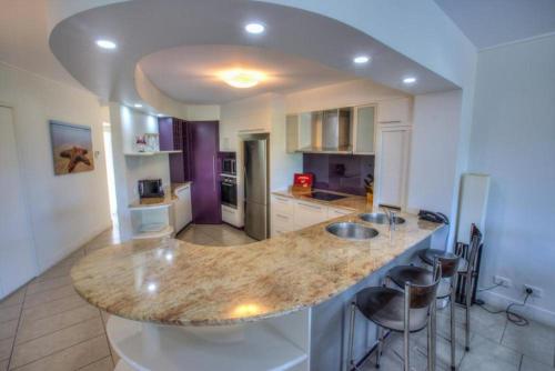 a kitchen with a large island with bar stools at Pavillions on 1770 in Agnes Water
