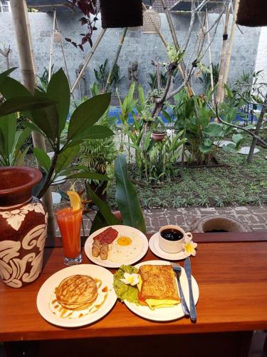 een tafel met twee borden met ontbijtproducten erop bij Nabali Villa2 in Kerobokan