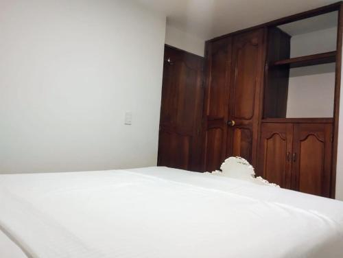 a bedroom with a bed and a wooden door at Habitación con cama queen y baño privado cerca del parque in La Ceja