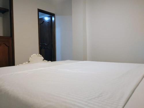 a close up of a white bed in a room at Habitación con cama queen y baño privado cerca del parque in La Ceja
