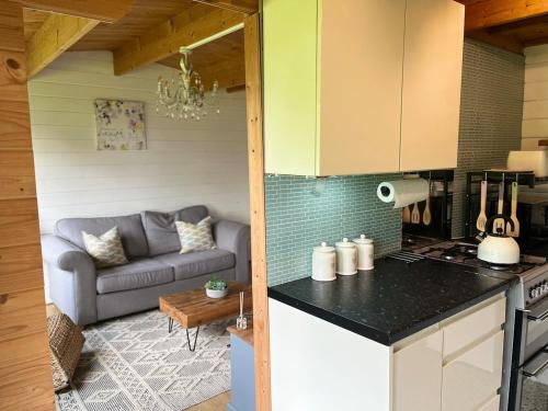 a kitchen and a living room with a couch at Walland Cottage Romney Retreat in Old Romney