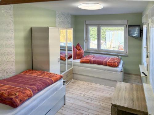 a bedroom with two beds and a window at Zur Teufelsmauer in Vorwerk Helsungen