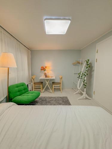 een slaapkamer met een groene stoel en een tafel bij Ahyeon Station 10-minute walk Cozy Stay in Seoul