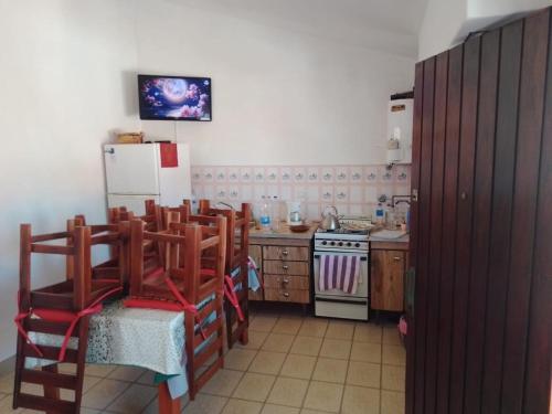 a kitchen with wooden cabinets and a white refrigerator at Departamento para 5 personas en Mar De Ajó in Mar de Ajó