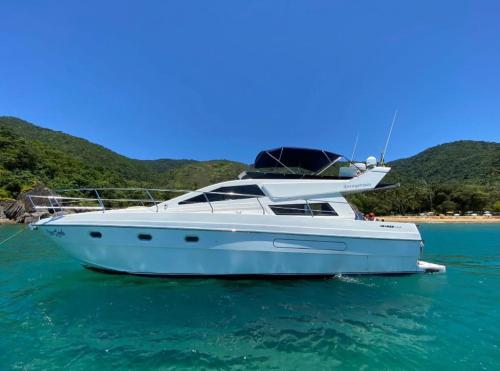 a white boat sitting in the water in the ocean at Iate de luxo Intermarine 44 pés in Ilhabela