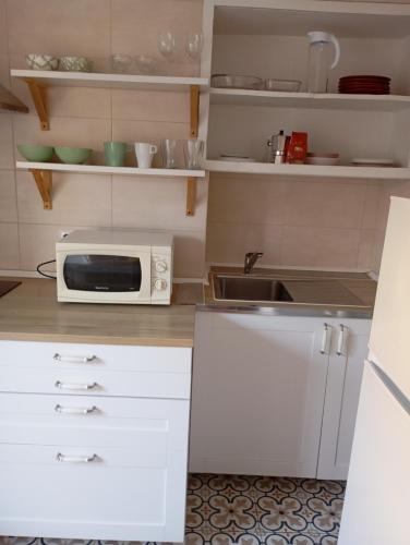 a kitchen with a microwave and a sink at Aliciamar E by Casas de Setúbal in Setúbal