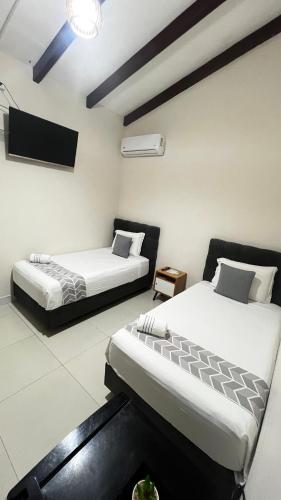 a room with two beds and a tv in it at Gaman Hotel Glamping in Santa Cruz de la Sierra