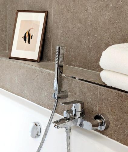 a bathroom with a sink and a bath tub with a picture at Suite D in Bad Dürkheim