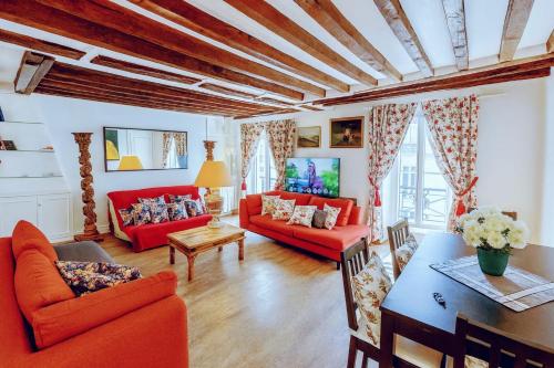 a living room with red couches and a table at Spacious Apartment in Montparnasse in Paris
