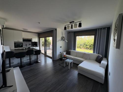 a living room with a white couch and a kitchen at Apartment Villa Anima in Kostrena