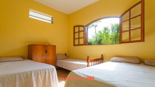 a bedroom with two beds and a window at Casa ampla em Mairinque com lazer completo in Mairinque