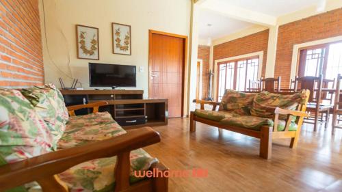 a living room with a couch and a tv at Casa ampla em Mairinque com lazer completo in Mairinque