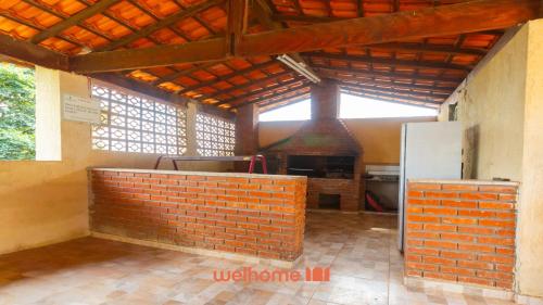 a kitchen with a brick wall and a brick oven at Casa ampla em Mairinque com lazer completo in Mairinque