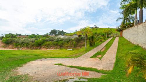 a path in a field next to a wall at Casa ampla em Mairinque com lazer completo in Mairinque