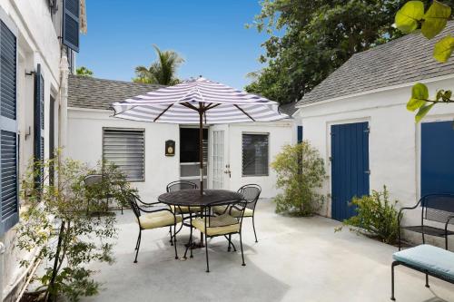 a patio with a table and chairs and an umbrella at Tamarind home in Governorʼs Harbour