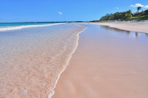 a sandy beach with waves coming in from the ocean at Lillian's Cottage cottage in Harbour Island