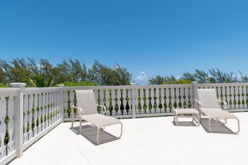 two chairs on a porch with a fence at Sundowner Villa villa in Savannah Sound