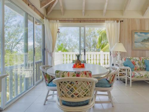 a screened in porch with a table and chairs at Sundowner Villa villa in Savannah Sound