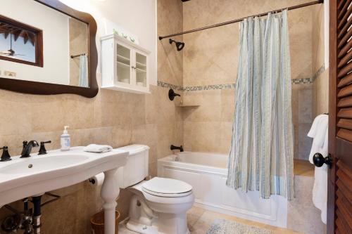 a bathroom with a sink and a toilet and a bath tub at Coconut Point home in Palmetto Point