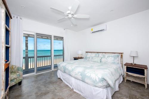 a bedroom with a bed and a view of the ocean at Caribbean SandCastle home in James Cistern