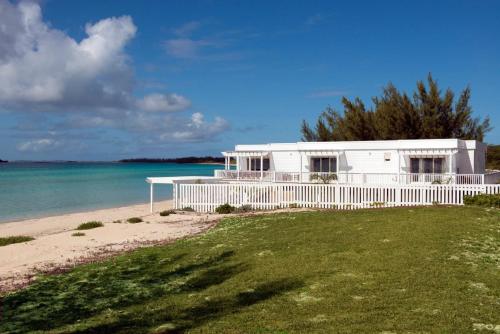 a white house on a beach next to the ocean at Caribbean SandCastle home in James Cistern