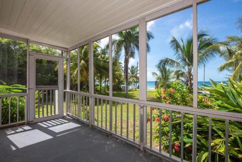 an empty porch with a view of the ocean at Winfield Manor home in Governorʼs Harbour