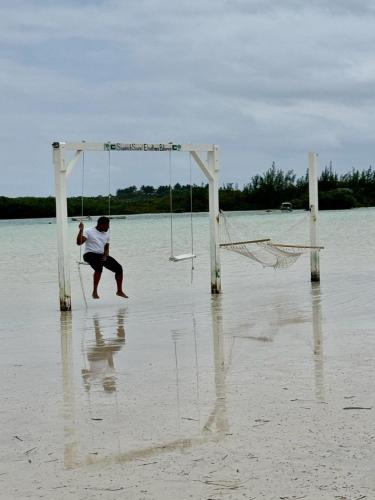 a man is playing on a net on the beach at Winfield Manor home in Governorʼs Harbour