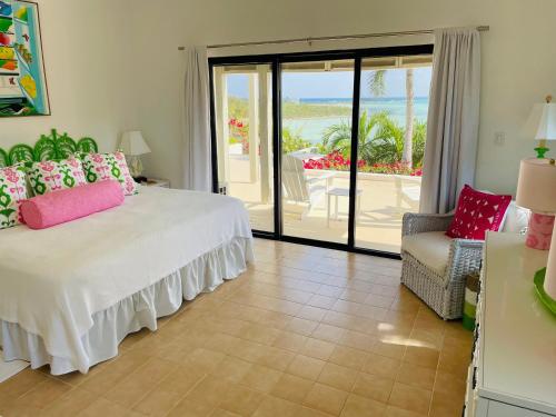 a bedroom with a bed and a view of the ocean at Halcyon House home in Savannah Sound