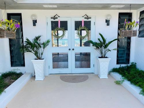 a front door of a house with two potted plants at Halcyon House home in Savannah Sound