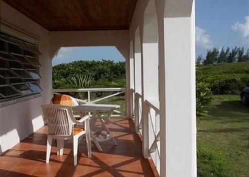 a patio with a table and chairs on a porch at Atlantic Sunrise Villa villa in James Cistern