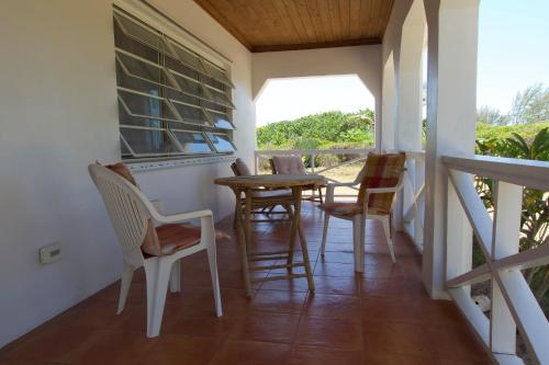 a room with a table and chairs on a porch at Atlantic Sunrise Villa villa in James Cistern