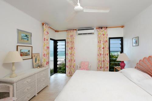 a white bedroom with a bed and a window at Provender home in Savannah Sound