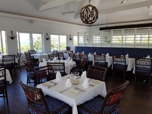 a dining room with white tables and chairs at Provender home in Savannah Sound