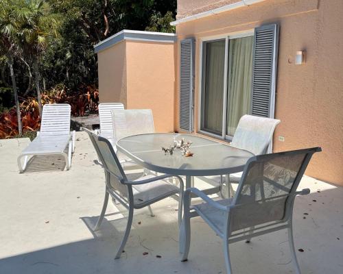 a glass table and chairs on a patio at Sunnyside home in Savannah Sound