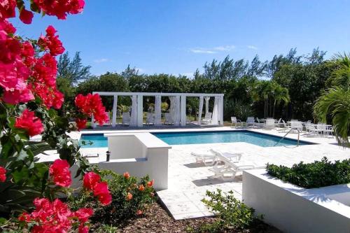 a swimming pool with red flowers in a yard at Sunnyside home in Savannah Sound