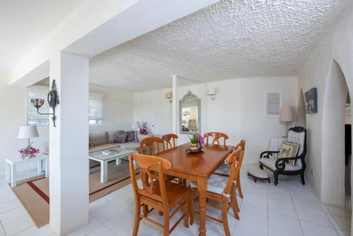 a dining room and living room with a table and chairs at Indigo House home in Governorʼs Harbour