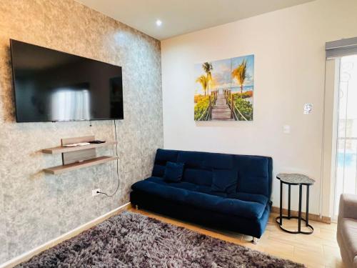 a living room with a blue couch and a tv at Charming San Carlos BB with Private Pool BBQ in San Carlos